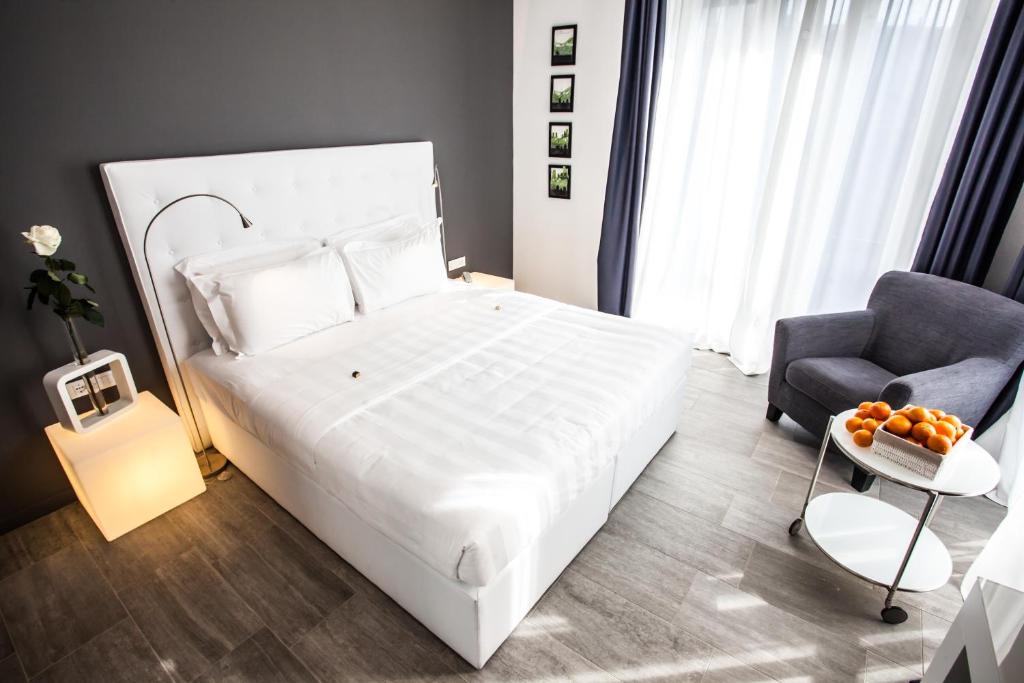 1 dormitorio con 1 cama blanca grande y 1 silla en Made to Measure Business, en Milán