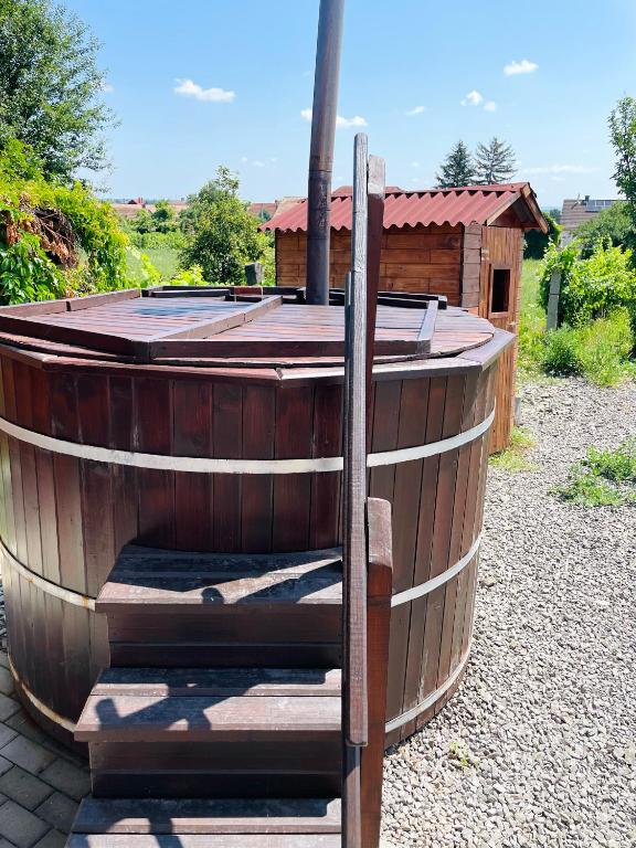 a large wooden barrel with a wooden house in the background at Maul - Lator vendégház in Villány