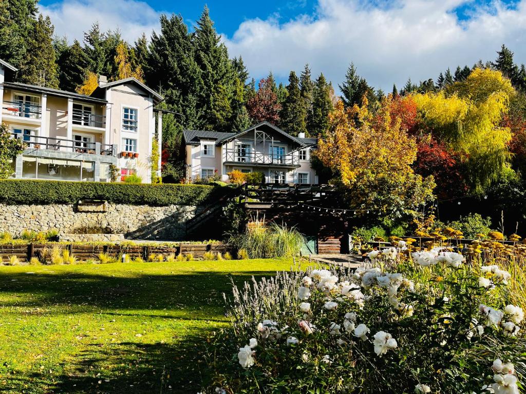 a large house in the middle of a garden at Aldea Andina Hotel&Spa in San Carlos de Bariloche