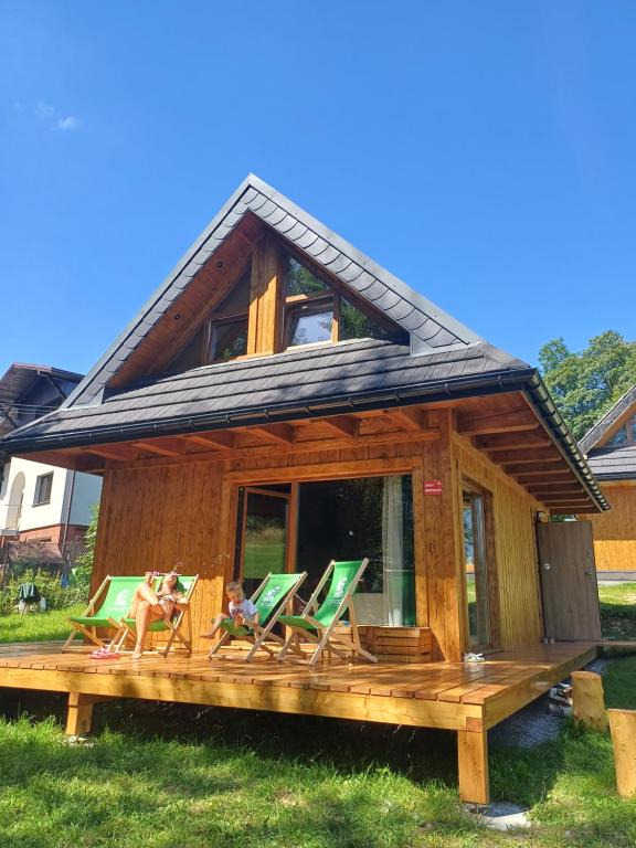 uma casa com quatro cadeiras de jardim num deque em Cichosza domek w Szczyrku em Szczyrk