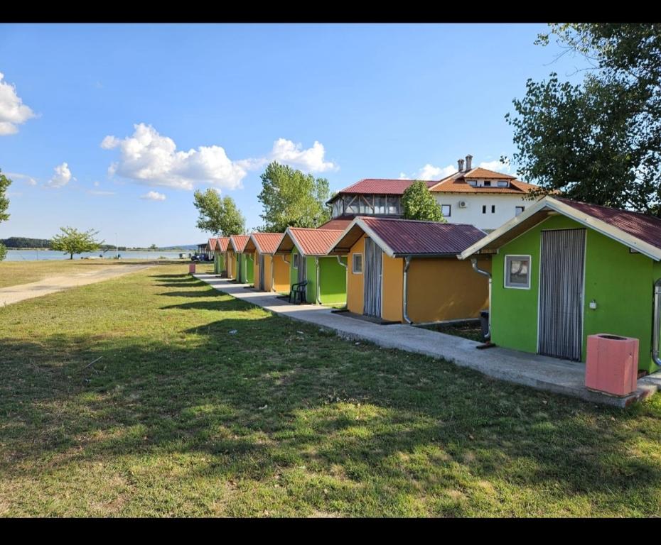 una fila di cabine sulla spiaggia su un campo erboso di Camp Miroc water 