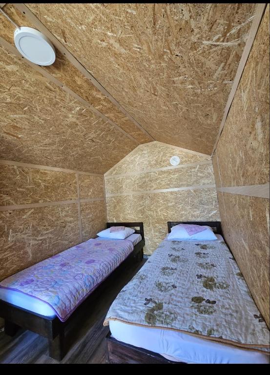 2 letti in una piccola camera con soffitto di Camp Miroc water 