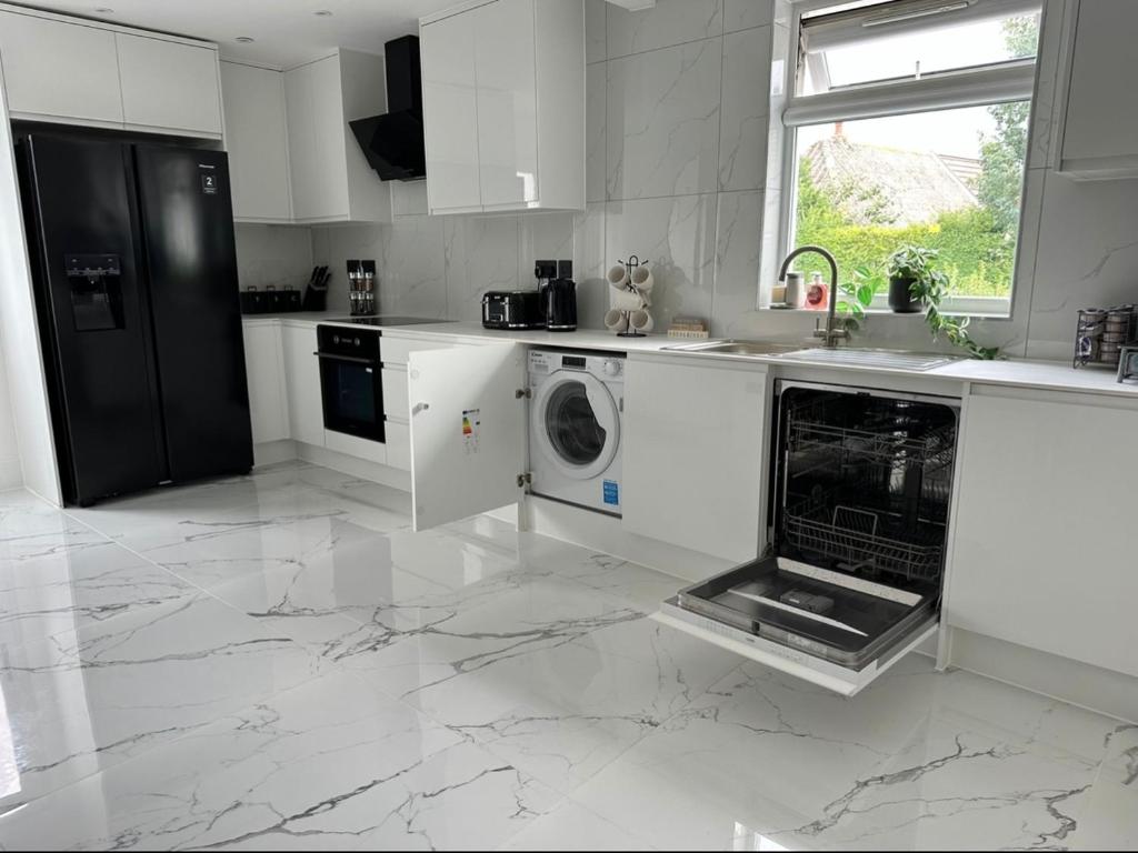 a white kitchen with a sink and a dishwasher at Entire home in Nottingham in Nottingham