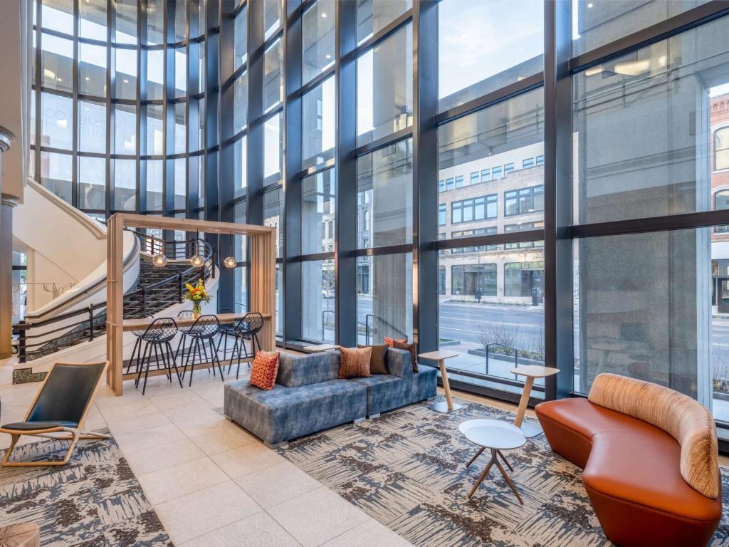 a lobby with a couch and chairs and windows at Hilton Garden Inn Toledo Downtown in Toledo