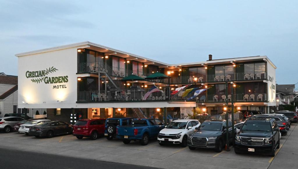 un gran edificio con coches estacionados en un estacionamiento en Grecian Garden Motel, en North Wildwood