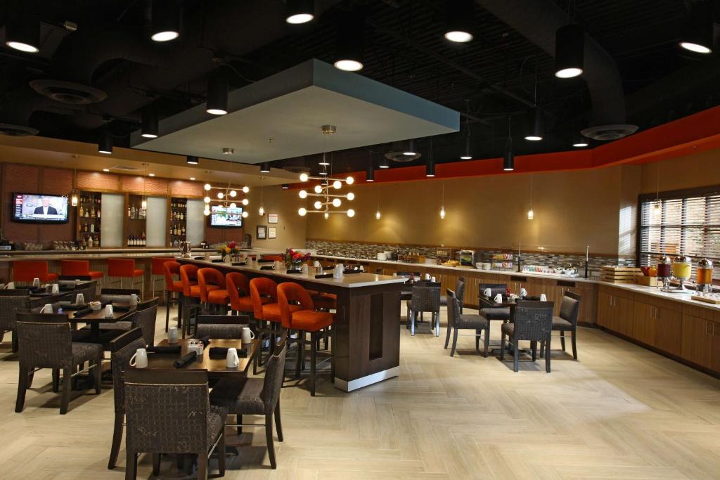 a restaurant with tables and chairs and a bar at DoubleTree by Hilton Johnson City in Johnson City