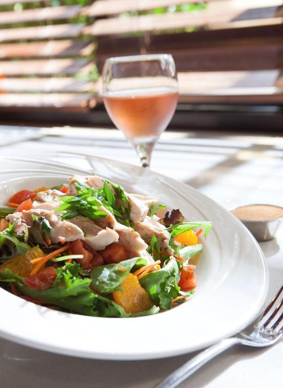 a white plate with a salad and a glass of wine at DoubleTree by Hilton Johnson City in Johnson City