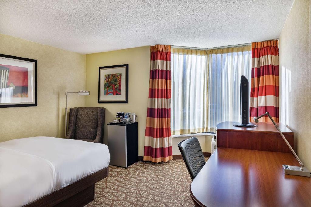 a hotel room with a bed and a desk with a computer at DoubleTree by Hilton Johnson City in Johnson City