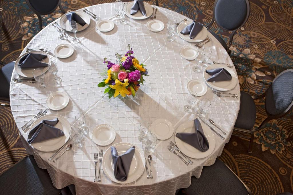 a white table with a flower arrangement on it at DoubleTree by Hilton Johnson City in Johnson City