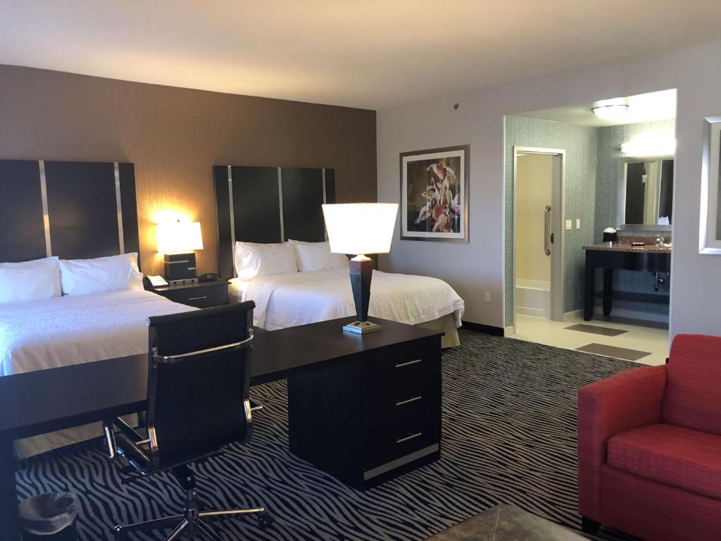 a hotel room with two beds and a desk at Hampton Inn and Suites Tulsa Central in Tulsa