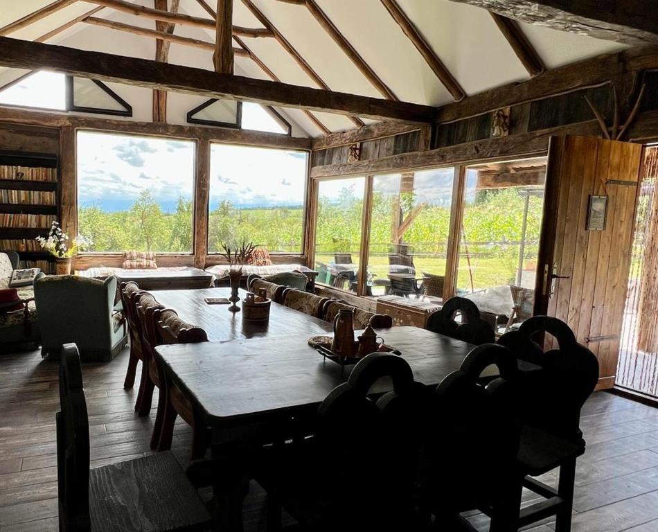 a dining room with a table and a large window at Casa din Deal-Cincu in Cincu