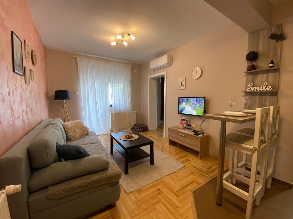 uma sala de estar com um sofá e uma mesa em Apartman_Krstić_1 em Subotica