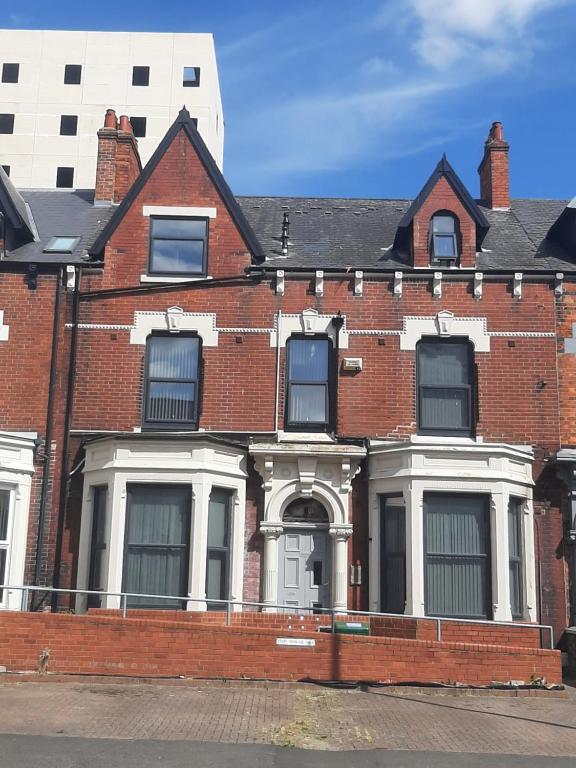 ein rotes Backsteinhaus mit einer weißen Tür in der Unterkunft Exclusive Self-contained flat in Middlesbrough in Middlesbrough