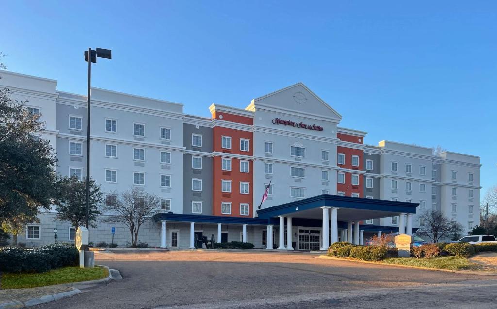 a large hotel with a red and white building at Hampton Inn & Suites - Vicksburg in Vicksburg