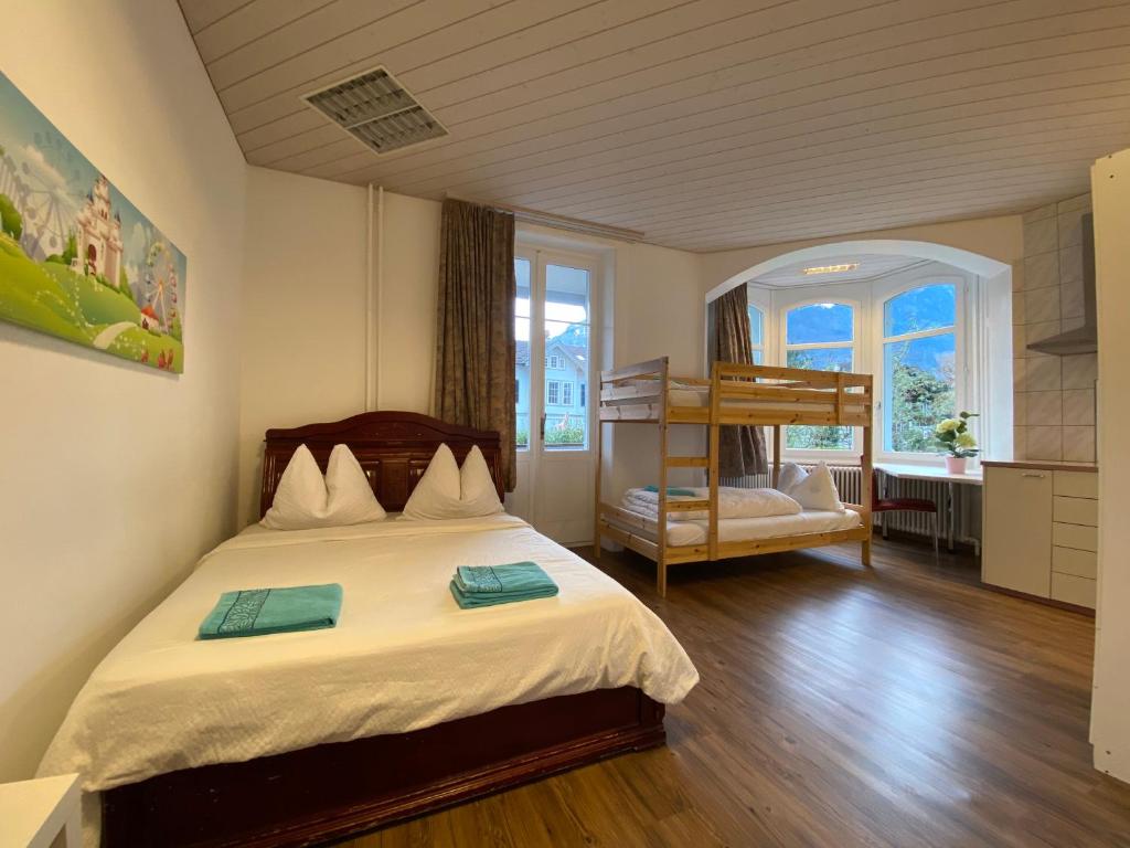 1 dormitorio con 1 cama y 1 litera en Interlaken Marco Hostel, en Interlaken