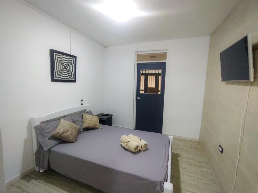 un dormitorio con una cama con un animal de peluche en Apartamento Sevilla, Valle del Cauca, en Sevilla