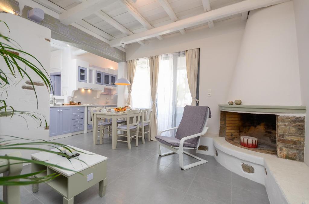 uma cozinha e sala de estar com lareira e mesa em Santa Katerina Apartments & Studios em Naxos Chora