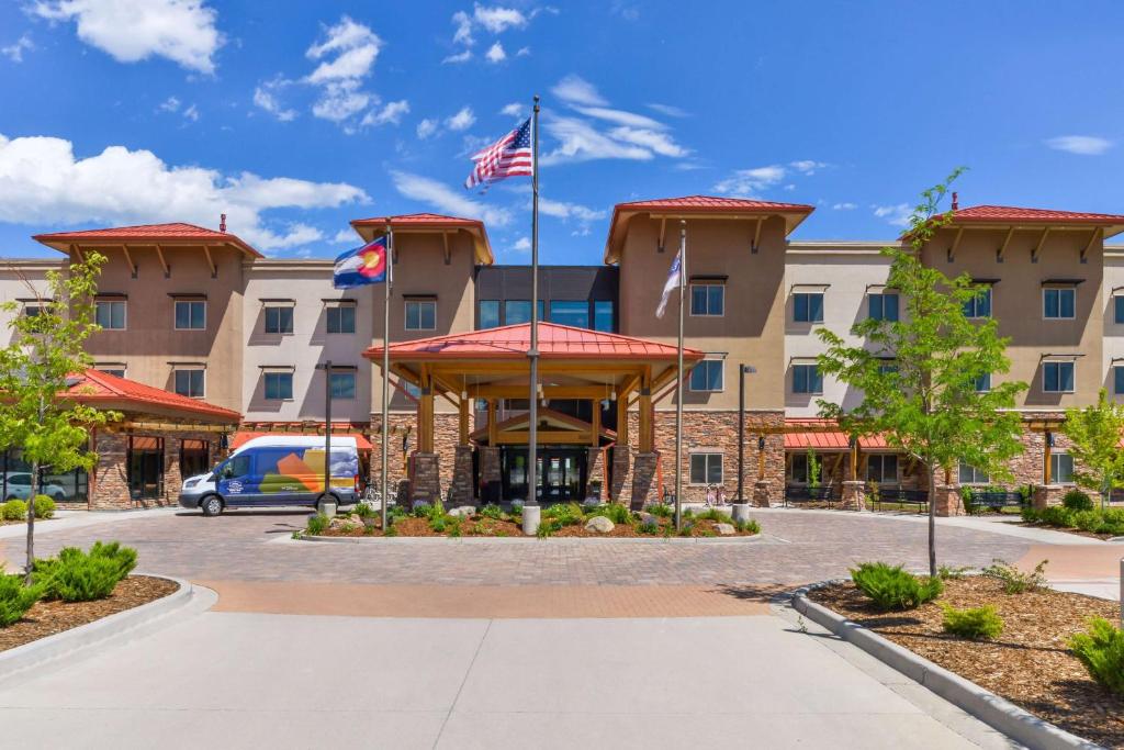 ein Bild von der Vorderseite eines Hotels mit amerikanischer Flagge in der Unterkunft Hampton Inn & Suites Boulder North in Boulder