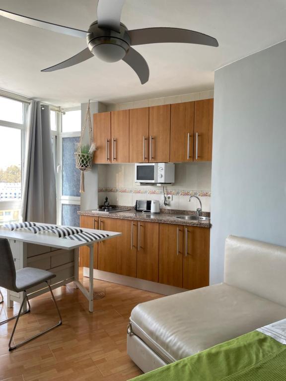kuchnia ze stołem i wentylatorem sufitowym w obiekcie Benalmadena ,apartamento-Estudio primera Línea de Playa w mieście Benalmádena