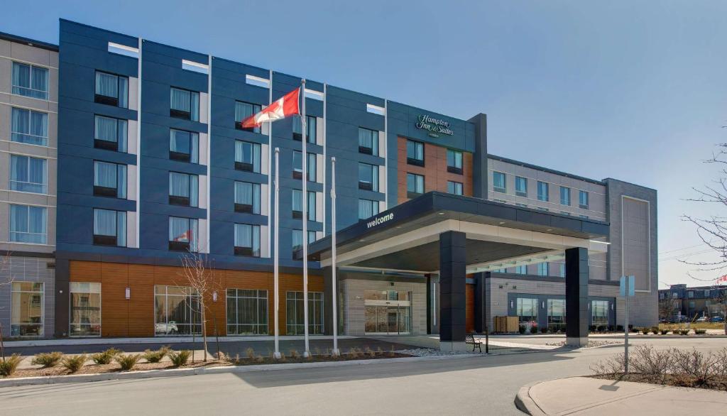 um hotel com uma bandeira canadiana em frente em Hampton Inn & Suites By Hilton Waterloo St. Jacobs em Waterloo