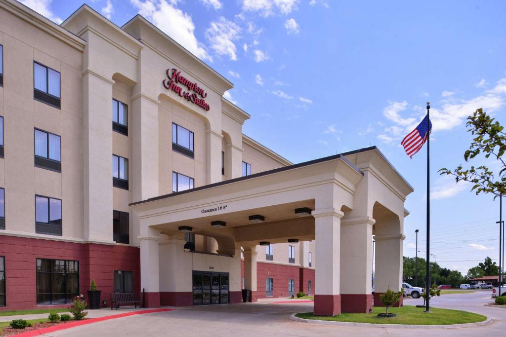 a hotel with an american flag in front of it at Hampton Inn & Suites Woodward in Woodward