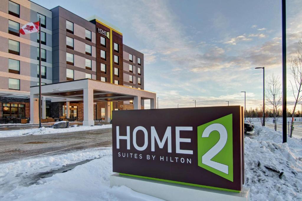 um sinal na neve em frente a um hotel em Home2 Suites By Hilton Edmonton South em Edmonton