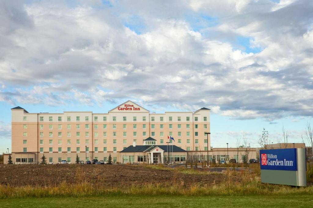 a large building with a sign in front of it at Hilton Garden Inn Edmonton International Airport in Leduc
