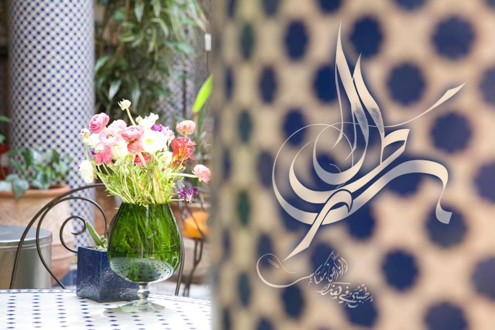 un vase de fleurs assis sur une table dans l'établissement Riad Al Bartal, à Fès