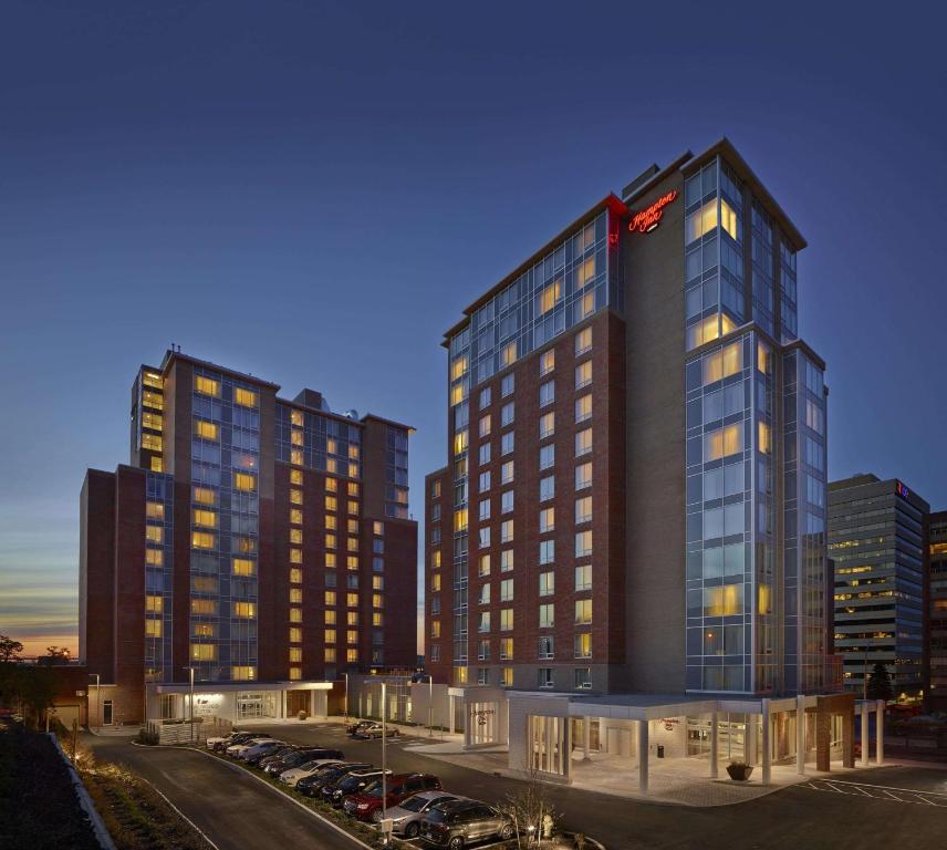 Un grand bâtiment avec des voitures garées dans un parking dans l'établissement Hampton Inn by Hilton Halifax Downtown, à Halifax