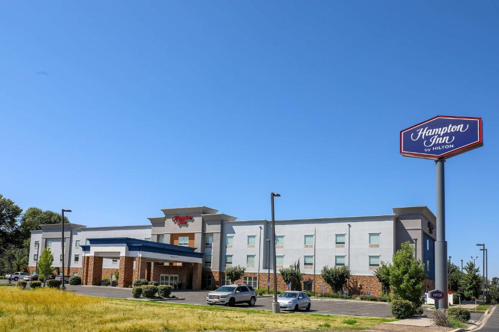 Hampton Inn Ellensburg في إلينسبورغ: فندق فيه سيارات تقف امام مبنى