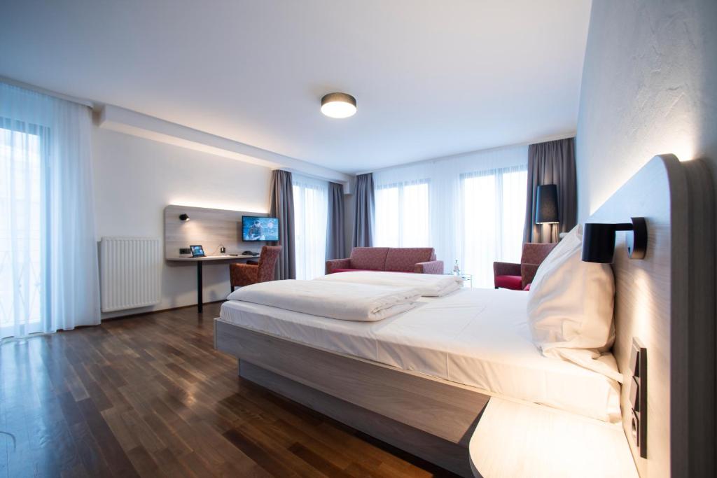 ケルンにあるエデン ホテル フルー アム ドムのベッドとデスクが備わるホテルルームです。
