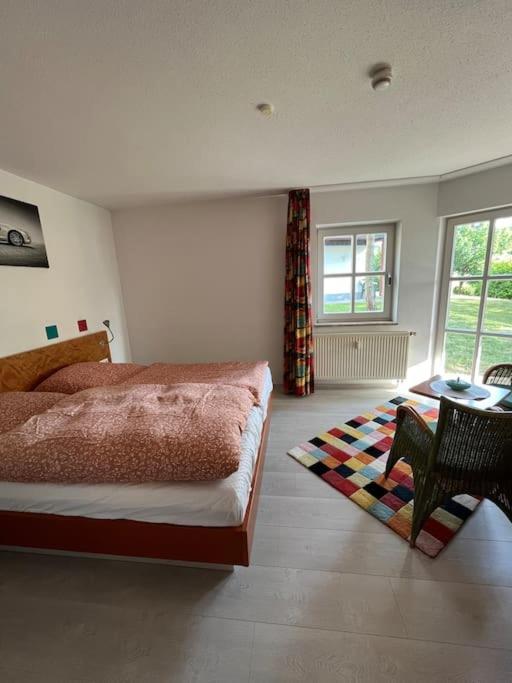 1 dormitorio con 1 cama, mesa y sillas en Idyllische Ferienwohnung am See, en Rötz