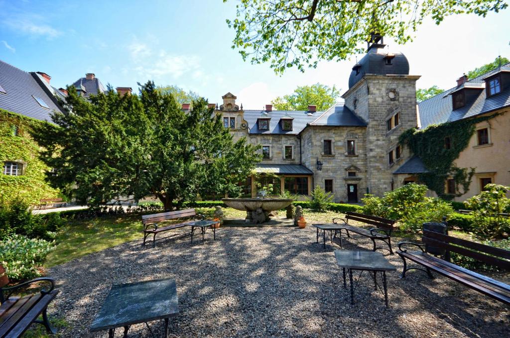 Peaceful courtyard with benches and greenery outside a historic building.