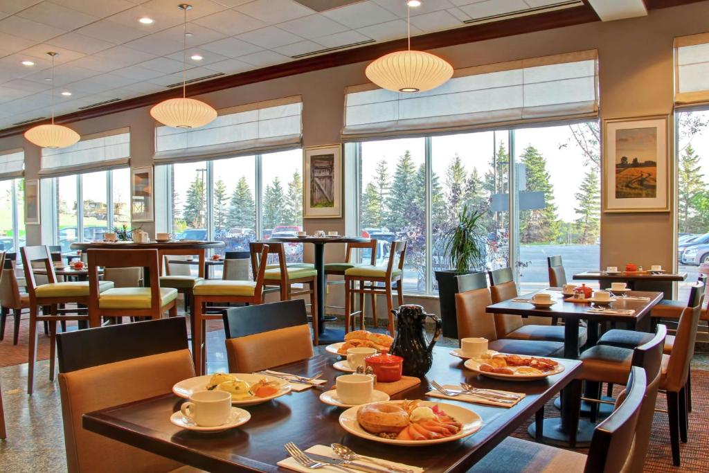 a restaurant with tables and chairs with food on them at Hilton Garden Inn Ottawa Airport in Ottawa