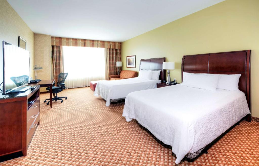 a hotel room with two beds and a television at Hilton Garden Inn Ottawa Airport in Ottawa