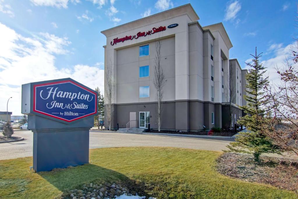 a hotel with a sign in front of a building at Hampton Inn & Suites Red Deer in Red Deer