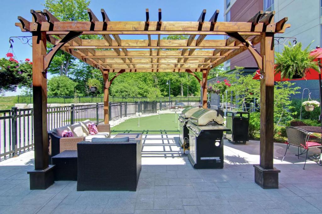 een houten pergola met een tennisbaan bij Homewood Suites by Hilton Toronto-Ajax in Ajax