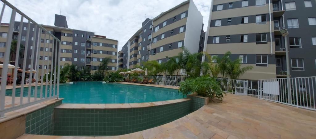 uma piscina no meio de um prédio em Apartamento Jardim das Palmeiras II - Ubatuba em Ubatuba