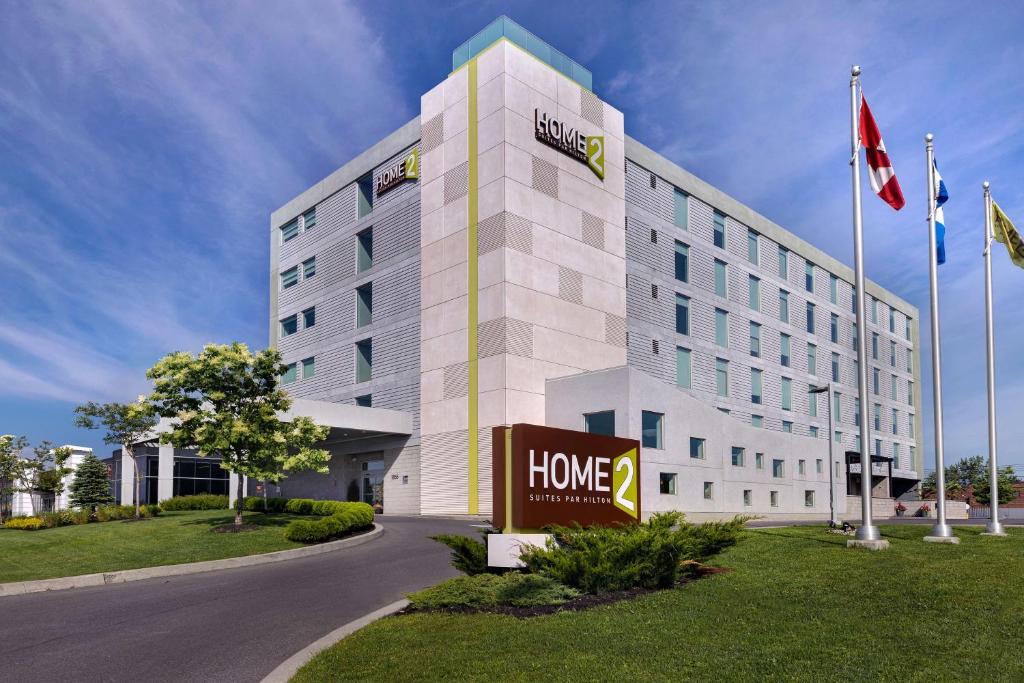 a hotel building with a sign in front of it at Home2 Suites By Hilton Montreal Dorval in Dorval