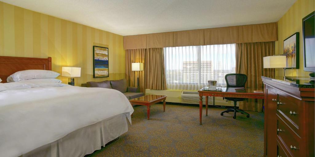 a hotel room with a large bed and a desk at Doubletree by Hilton London in London