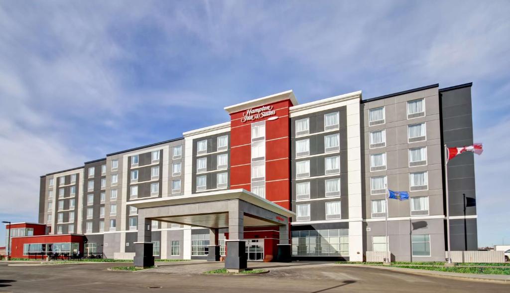 a hotel with a red and white building at Hampton Inn & Suites - Medicine Hat in Medicine Hat