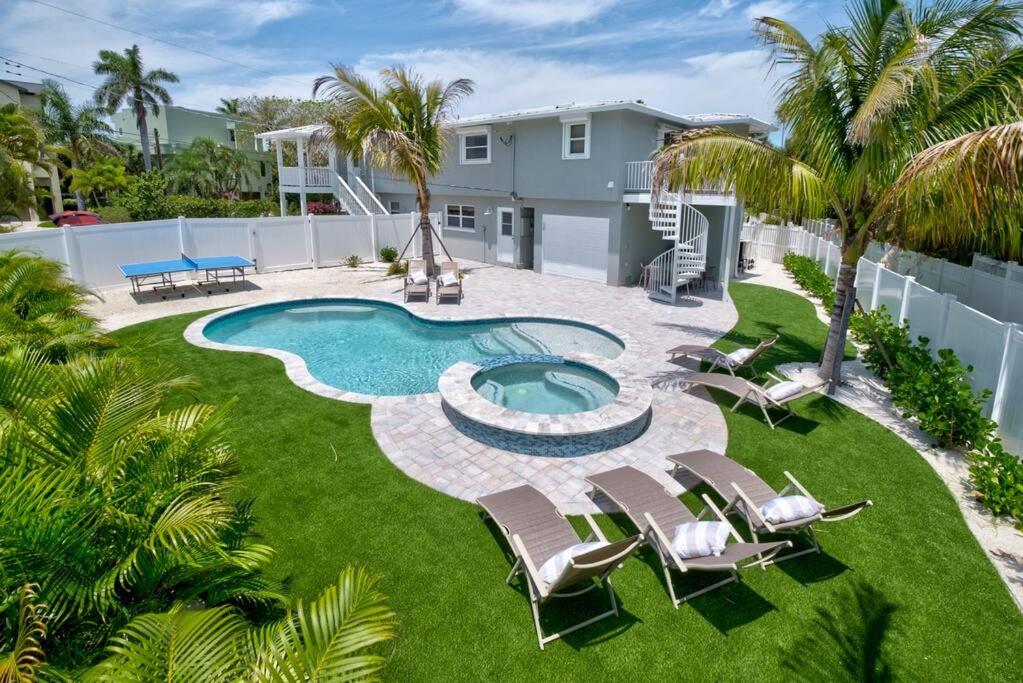 an image of a backyard with a swimming pool and chairs at Bean Point Residence in Anna Maria
