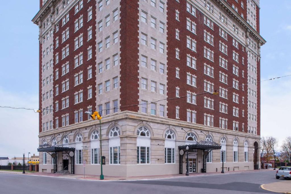 a large red brick building on a city street at DoubleTree by Hilton Utica in Utica