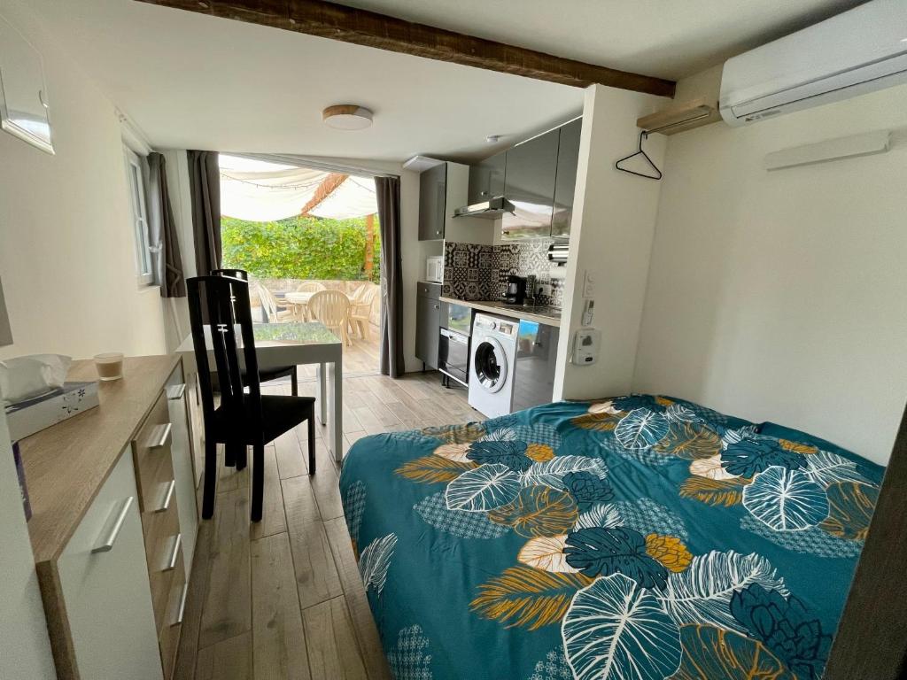 une chambre avec un lit et une table et une cuisine dans l'établissement Studio au calme climatisé avec terrasse, à Paillet