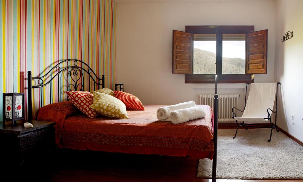 a bedroom with a bed with pillows and a window at El Rincón del Tiétar in Santa Maria del Tietar