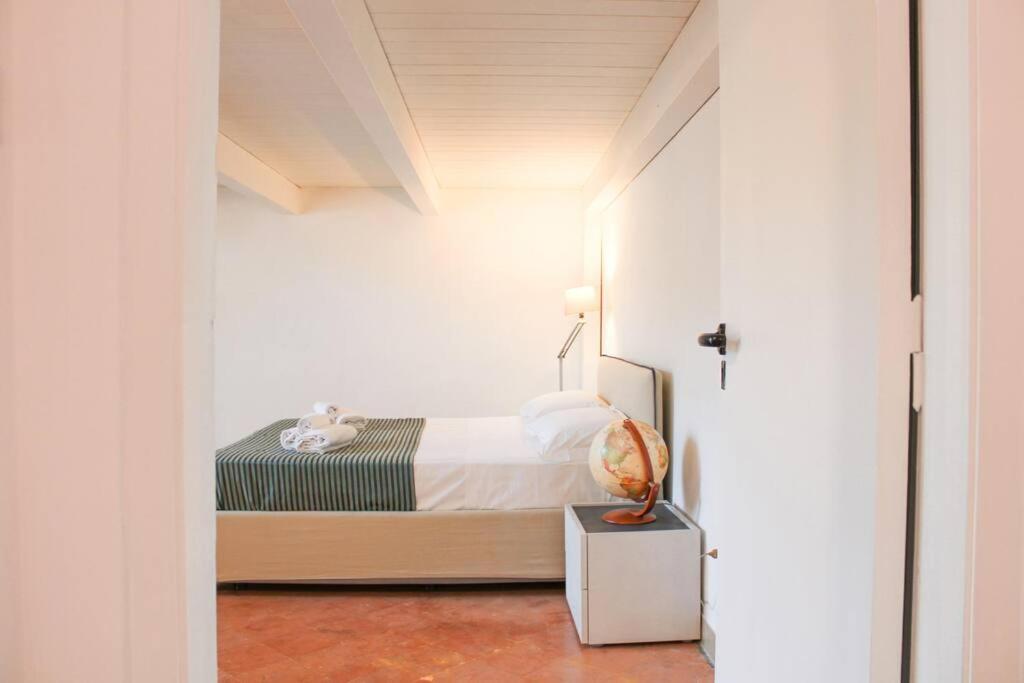 ein Schlafzimmer mit einem Bett in einem weißen Zimmer in der Unterkunft H.Verde Sorrento Apartment in Sant'Agnello