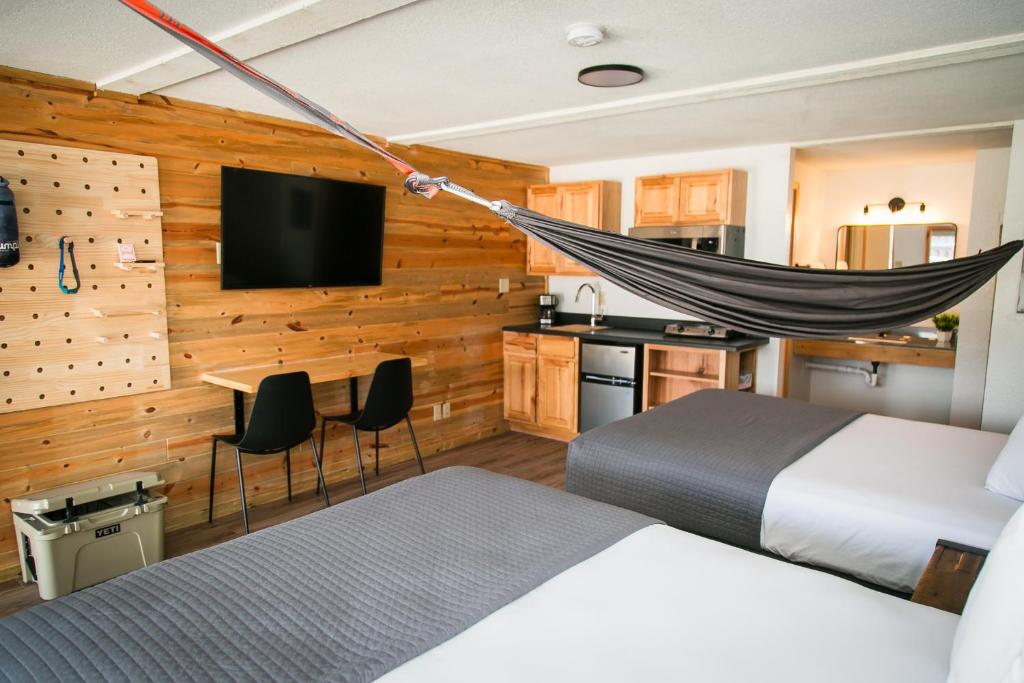Un dormitorio con una cama y una hamaca. en LOGE Wolf Creek, en South Fork