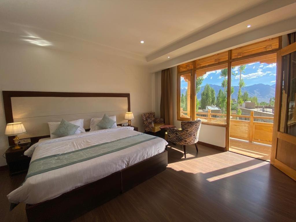 1 dormitorio con cama grande y ventana grande en Lha-Zes, en Leh