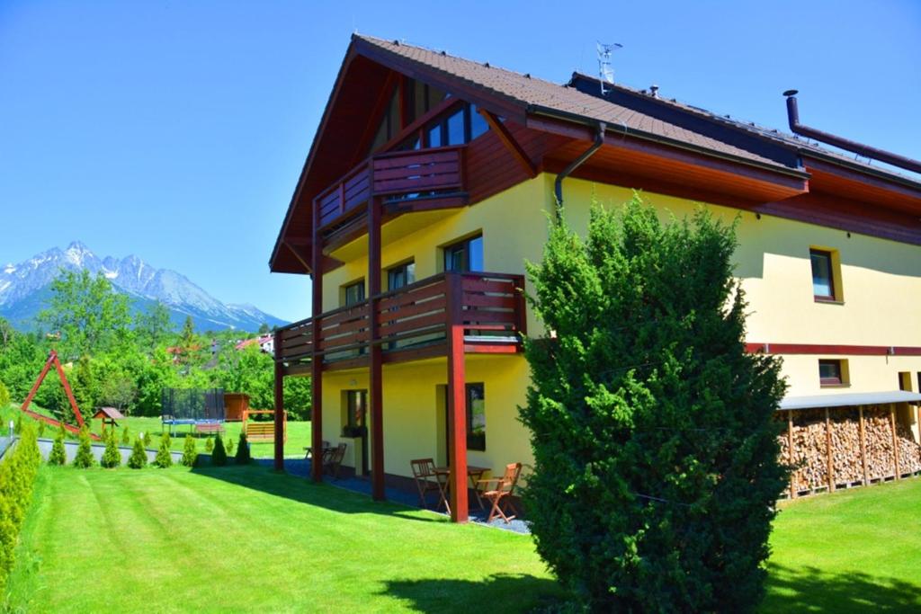 una casa con un patio verde con un árbol en Villa Gold en Nová Lesná