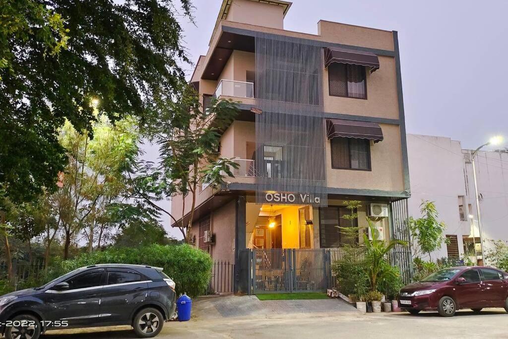 a building with two cars parked in front of it at 3 Luxury BedRoom Set OSHO Villa Jaipur Airport in Jaipur